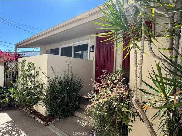 a front view of a house with plants