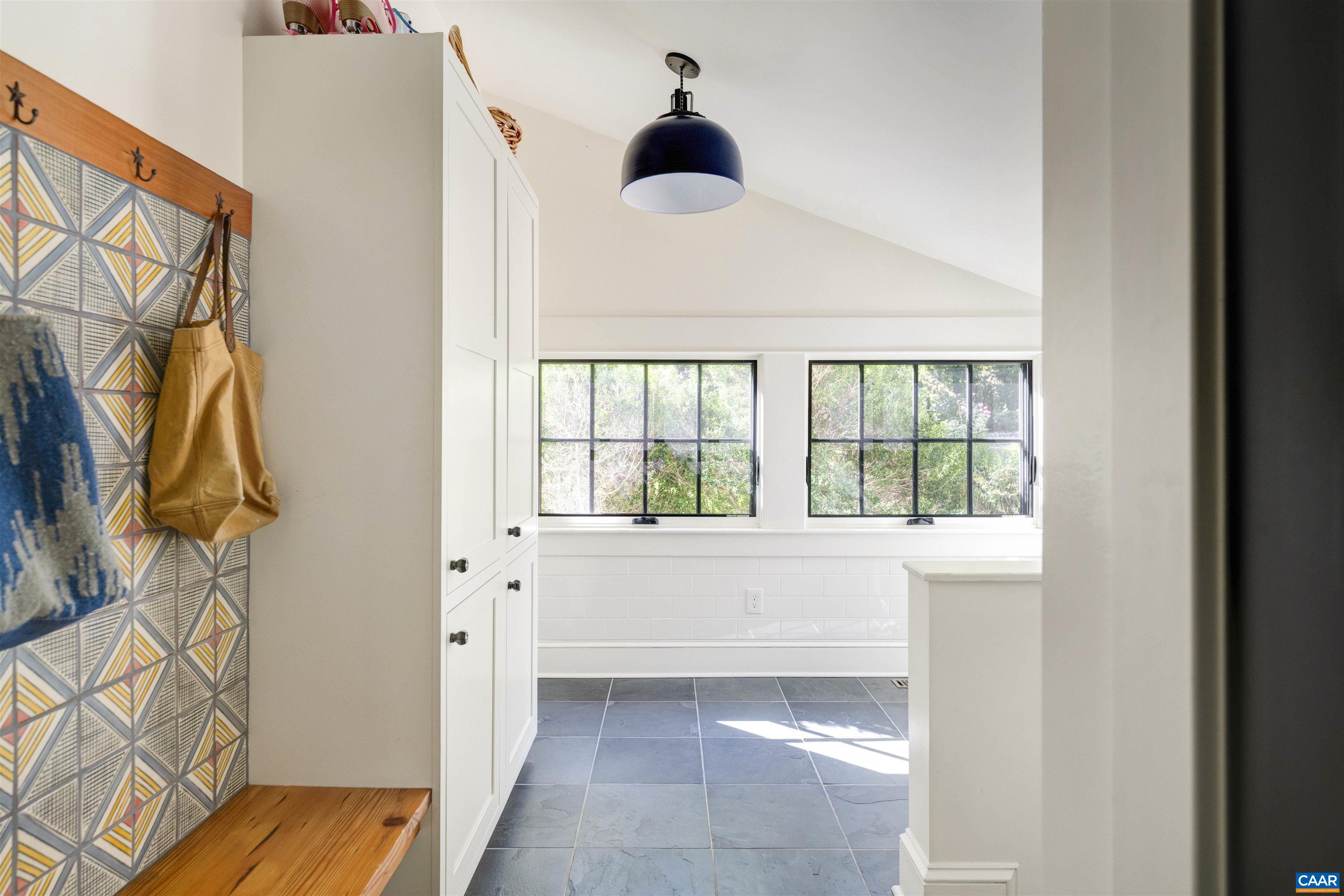 1535 Dairy Road Charlottesville, VA 22903 - Photo 21 of 70 a hallway with a black white checkered floor and a chandelier next to a window