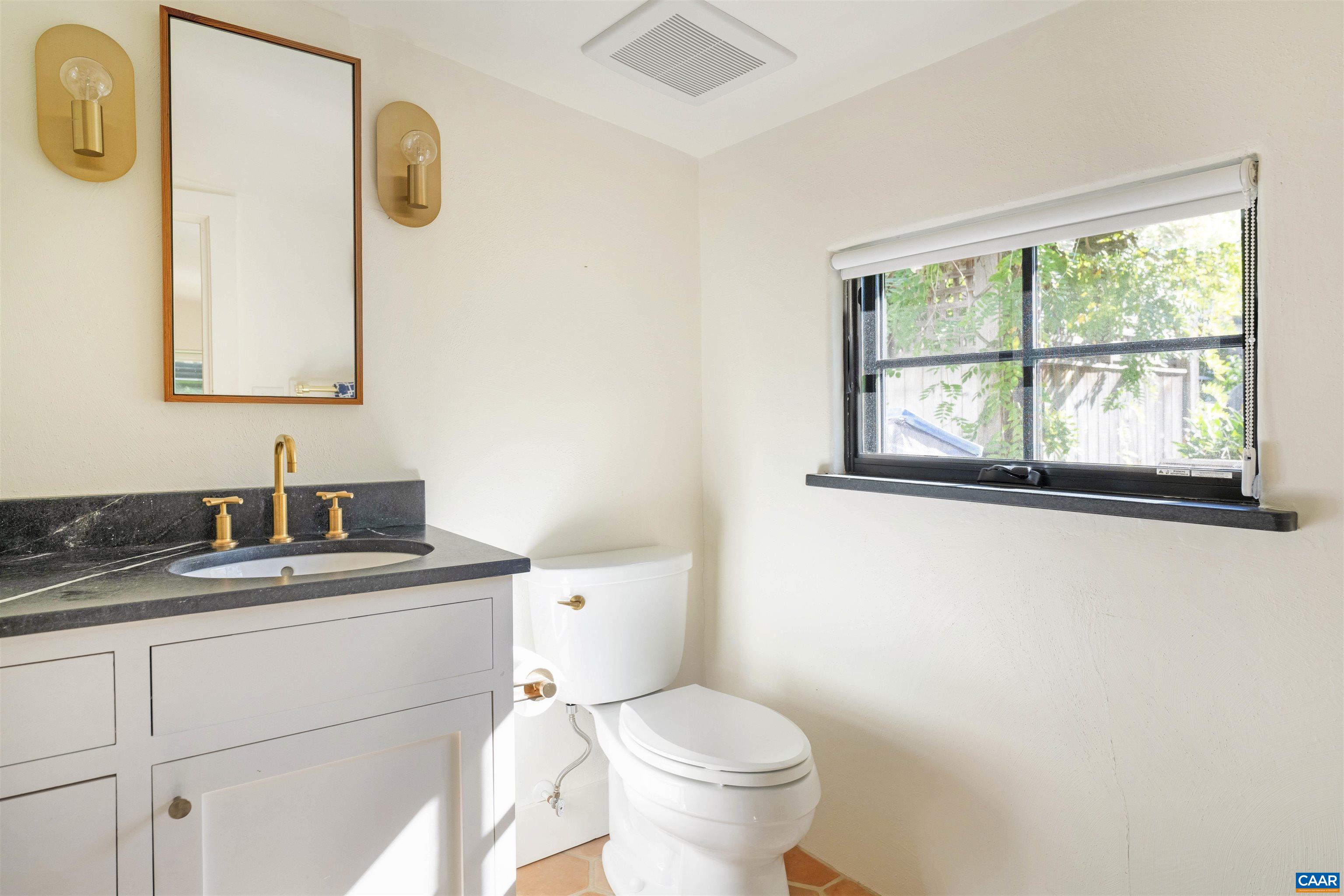 1535 Dairy Road Charlottesville, VA 22903 - Photo 56 of 70 a bathroom with a granite countertop toilet sink and mirror