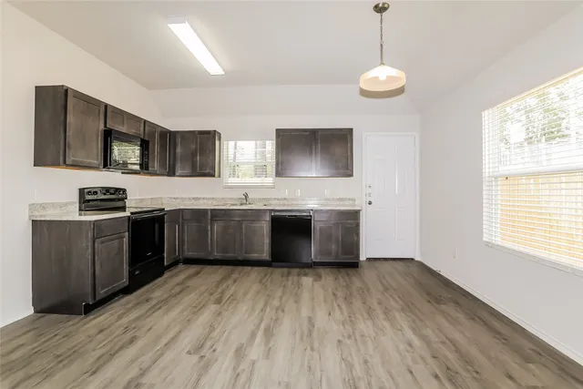 a kitchen with stainless steel appliances granite countertop a sink counter space cabinets and a large window
