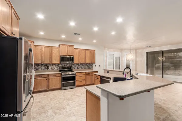 an empty room with a chandelier fan and windows