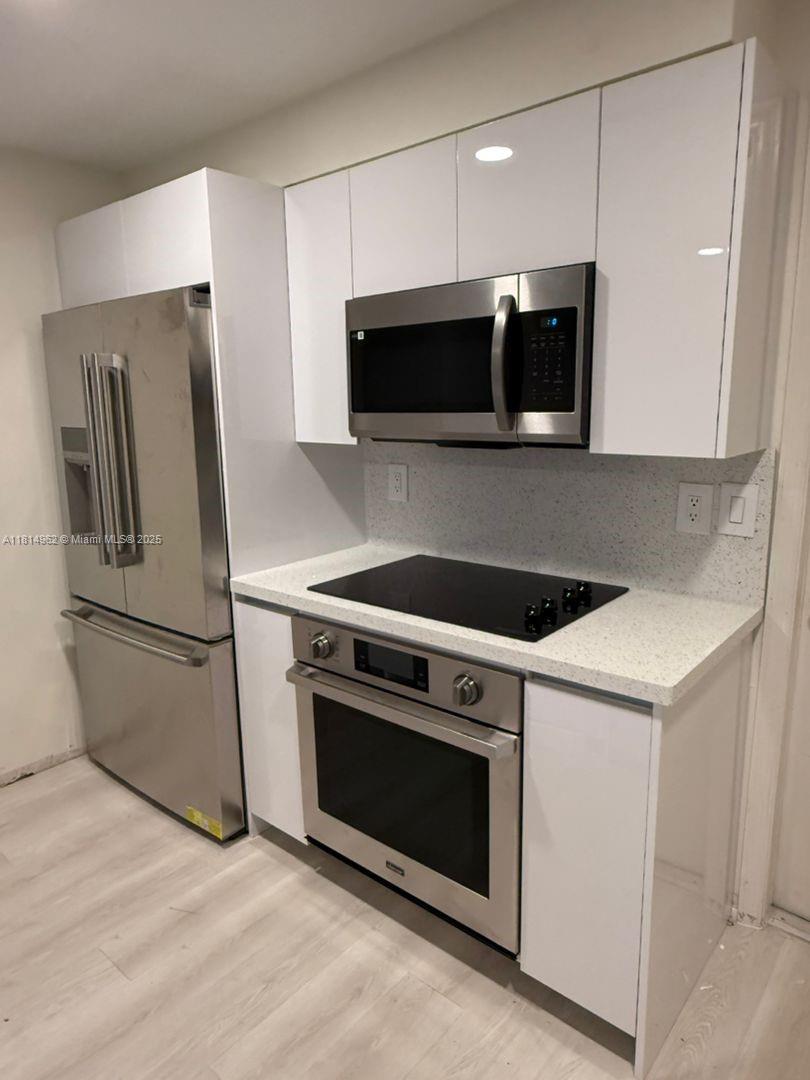 790 Sorrento Drive, Unit 790 Weston, FL 33326 - Photo 3 of 5 a kitchen with a stove microwave and refrigerator