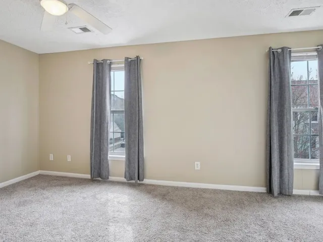 an empty room with windows and closet