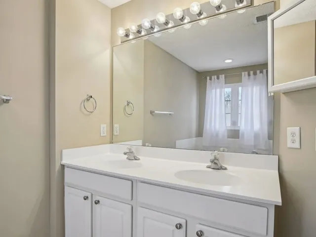 a bathroom with a sink double vanity and a mirror