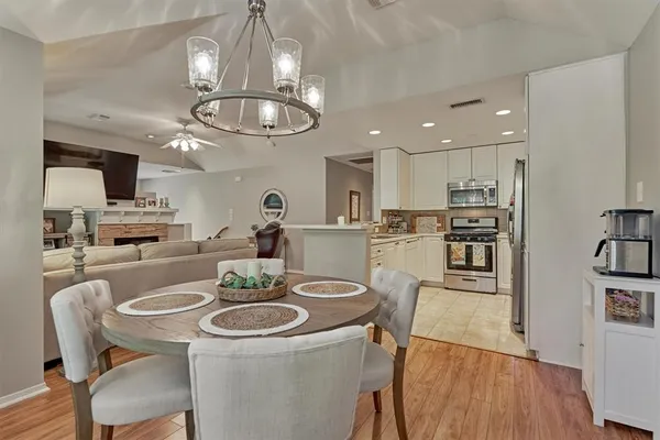 a kitchen with stainless steel appliances a table chairs and chandelier