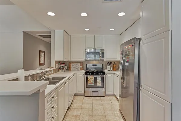 a kitchen with a sink stainless steel appliances and cabinets