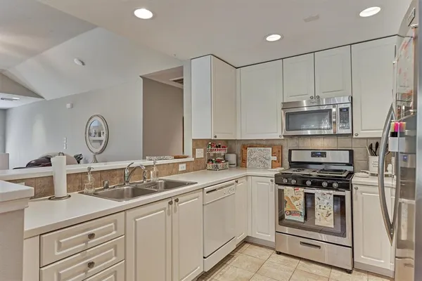 a kitchen with appliances a sink and cabinets