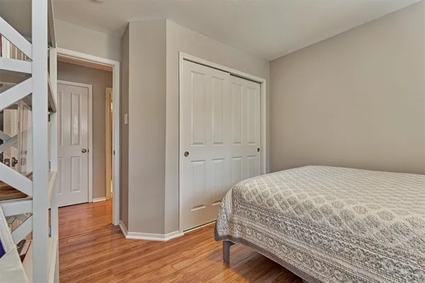 a bedroom with a bed and wooden floor