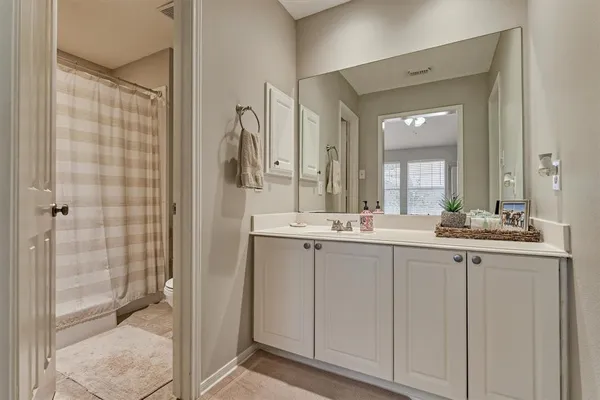 a bathroom with a granite countertop sink a mirror and a shower