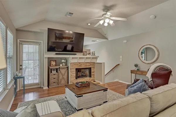 a living room with furniture a flat screen tv and kitchen view