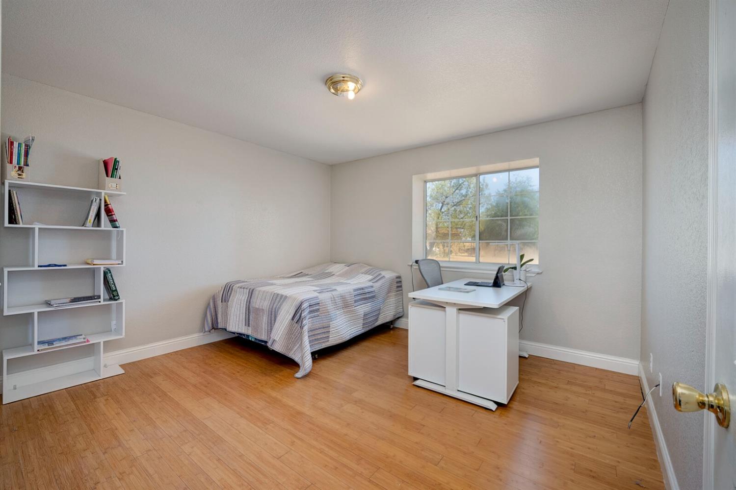 4427 East Catlett Road Lincoln, CA 95648 - Photo 25 of 51 a bedroom with a bed and a wooden floor