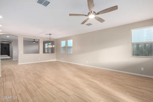 a large kitchen with stainless steel appliances kitchen island granite countertop a refrigerator a stove a sink and a wooden floors