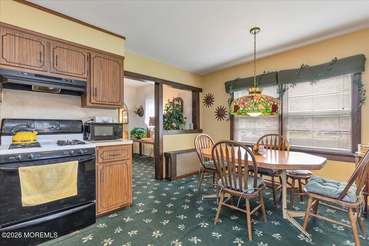 225 Freeman Street Woodbridge, NJ 07095 - Photo 12 of 39 a kitchen with stainless steel appliances granite countertop a stove a refrigerator a dining table and chairs with wooden floor