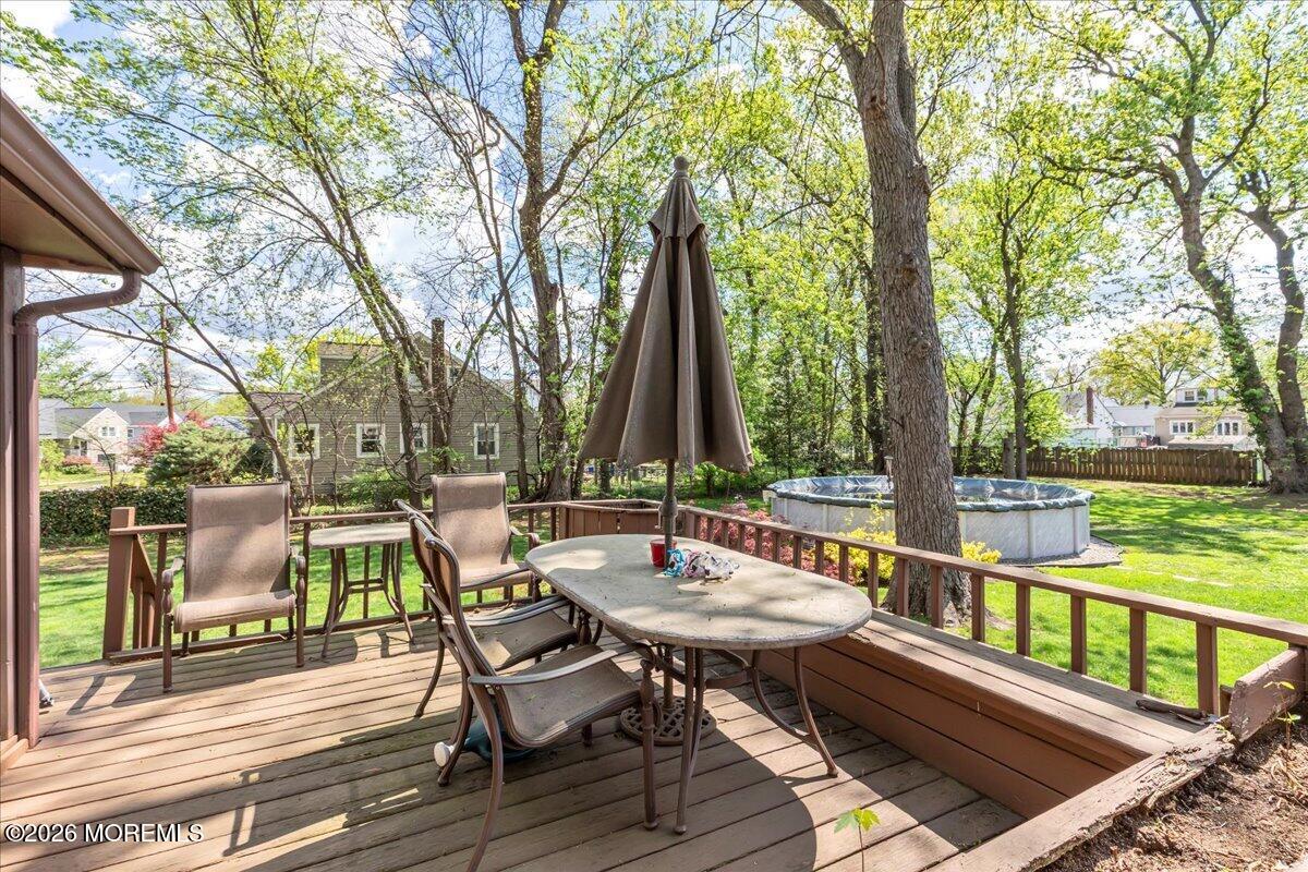 225 Freeman Street Woodbridge, NJ 07095 - Photo 32 of 39 a view of deck with furniture and a table and chairs under an umbrella