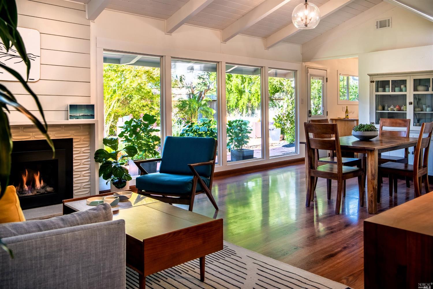 a living room with fireplace furniture and a large window