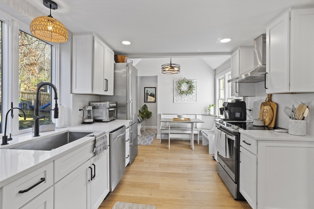 85 Red Acre Road Stow, MA 01775 - Photo 13 of 36 a kitchen with stainless steel appliances granite countertop a stove a sink dishwasher and a microwave oven with white cabinets