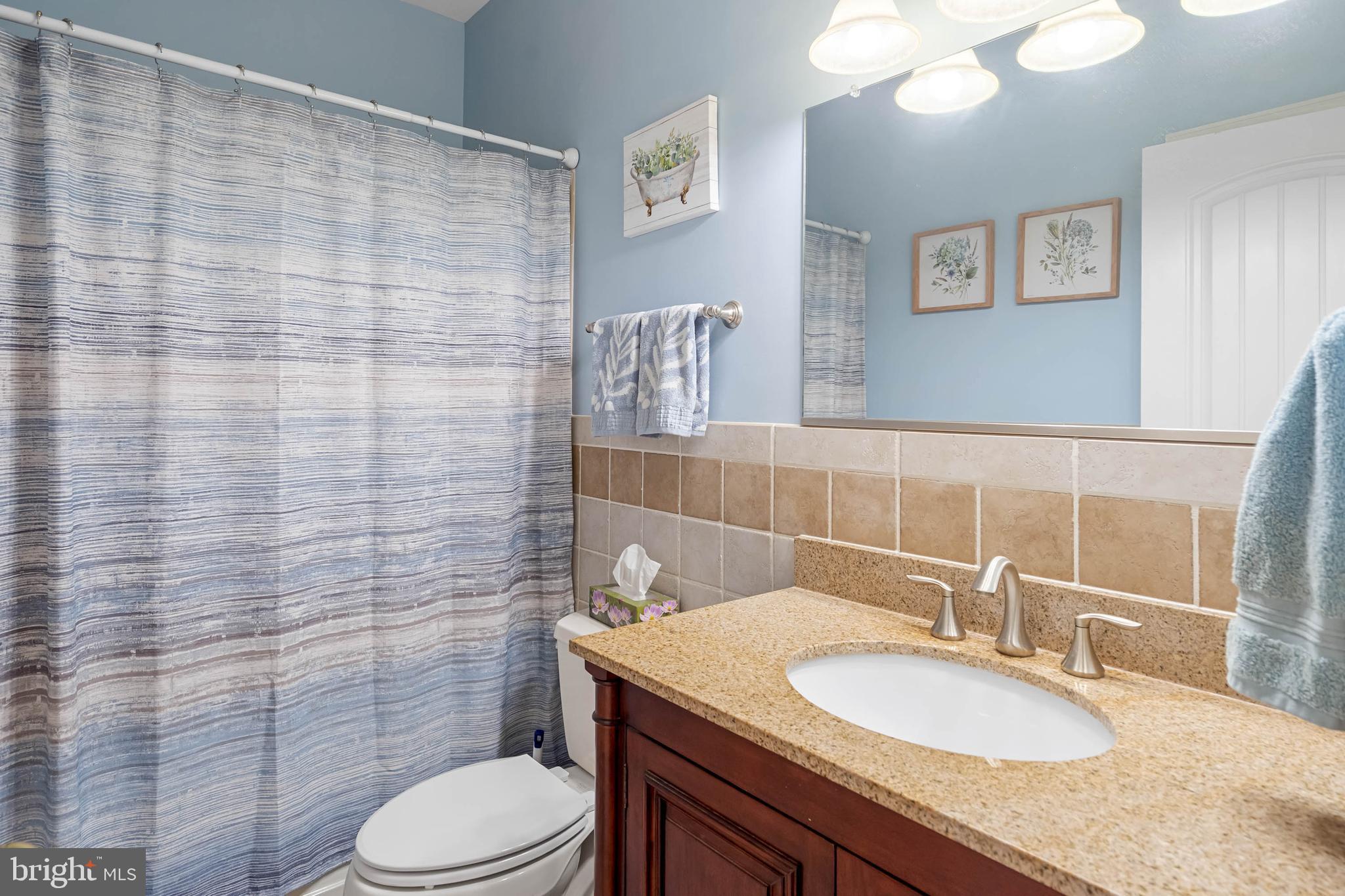 28344 River Road Seaford, DE 19973 - Photo 28 of 62 a bathroom with a granite countertop toilet sink and mirror