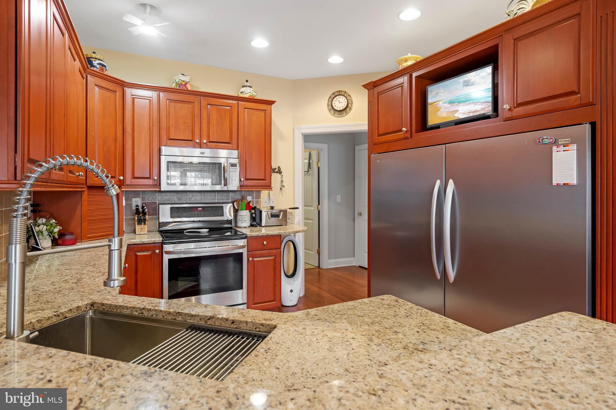28344 River Road Seaford, DE 19973 - Photo 4 of 62 a kitchen with stainless steel appliances granite countertop a refrigerator a stove and a sink with wooden floors