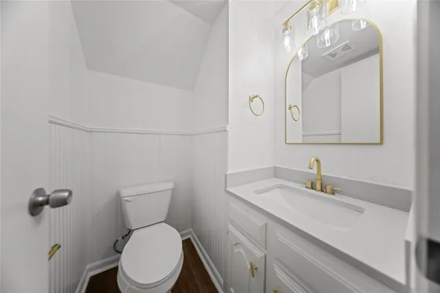 a bathroom with a toilet a sink and mirror