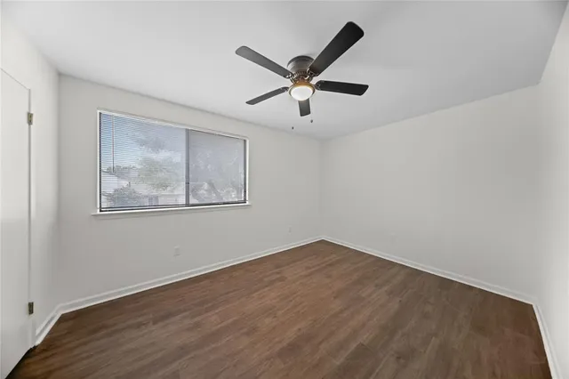 a view of a big room with wooden floor and windows