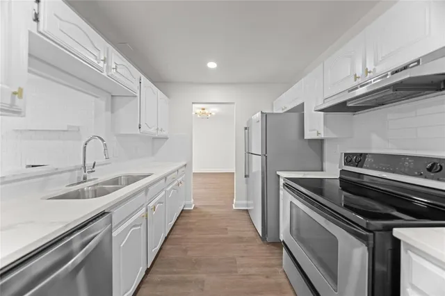 a kitchen with stainless steel appliances granite countertop a sink and a refrigerator