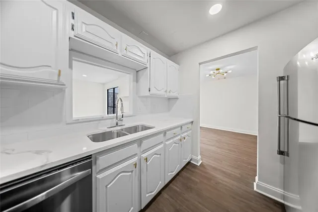 a kitchen with a sink cabinets stainless steel appliances and a window