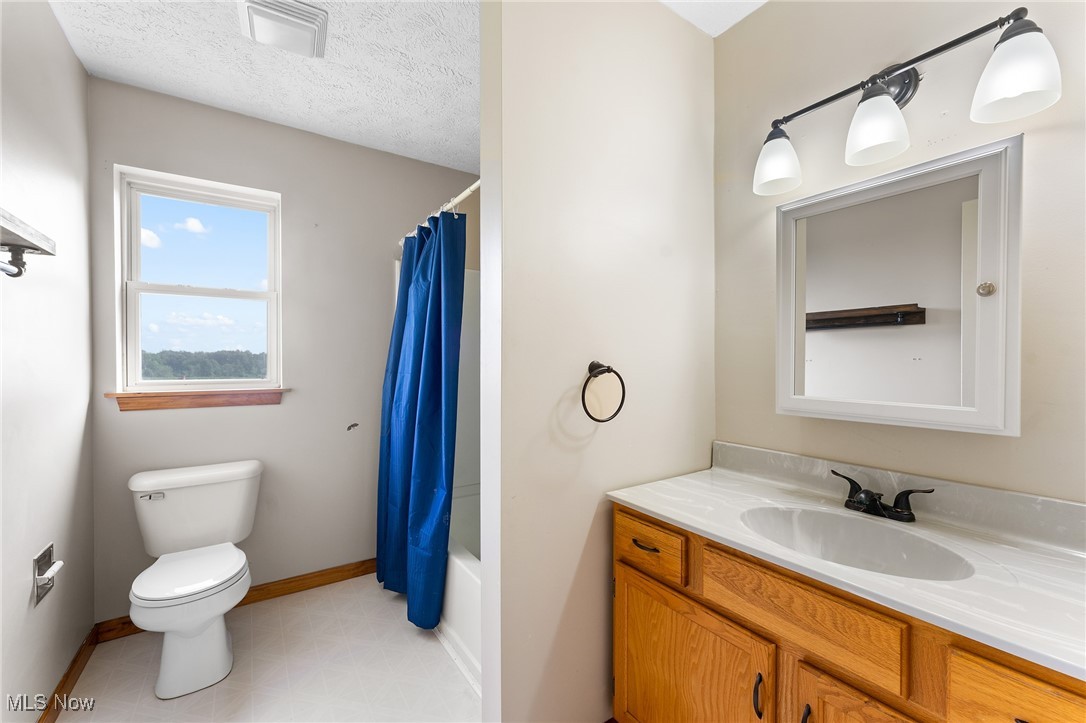 6272 Merwin Chase Road Brookfield, OH 44403 - Photo 25 of 38 Full bathroom with a textured ceiling, shower / bath combo with shower curtain, toilet, tile patterned floors, and vanity