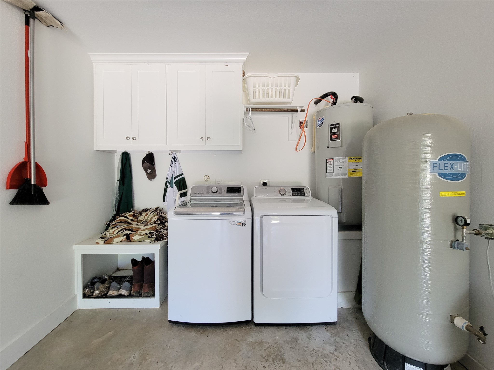 4937 Wolff Road Round Top, TX 78954 - Photo 28 of 31 This garage features a convenient laundry area with upper cabinets, a water heater, and a water well system.
