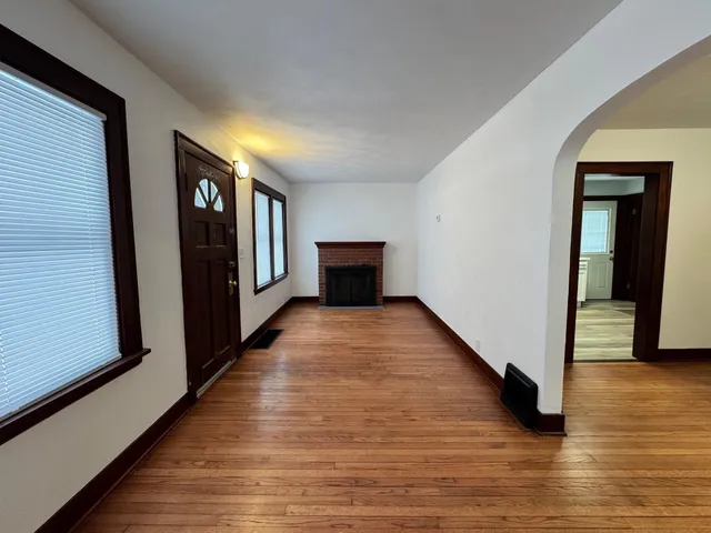 a view of a hallway with wooden floor and furniture