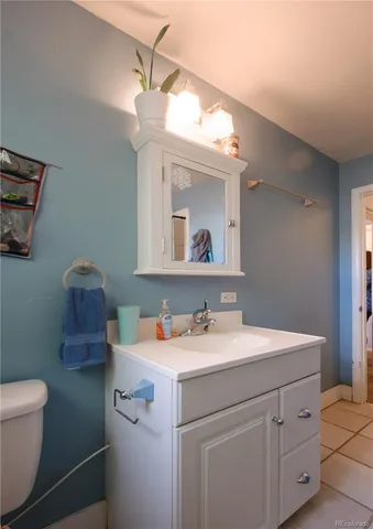 a bathroom with a sink vanity granite and toilet