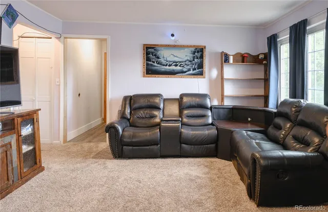 a living room with furniture a window and a flat screen tv