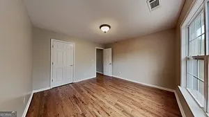 a view of an empty room with wooden floor