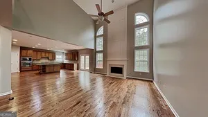 a kitchen with stainless steel appliances granite countertop a refrigerator a sink dishwasher a oven and a dining table with wooden floor