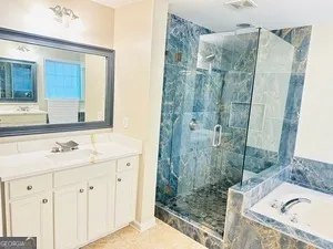a bathroom with a tub double vanity sink and mirror