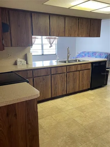 a kitchen with a sink a window and cabinets