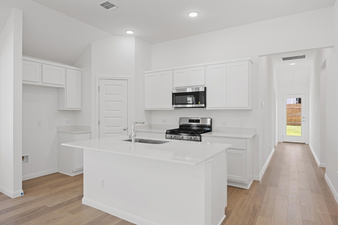 1251 Minorca Street Huffman, TX 77336 - Photo 4 of 24 a kitchen with appliances a sink a counter space and cabinets
