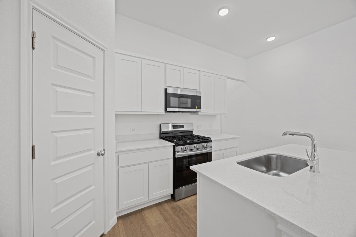 1251 Minorca Street Huffman, TX 77336 - Photo 8 of 24 a kitchen with white cabinets and stainless steel appliances