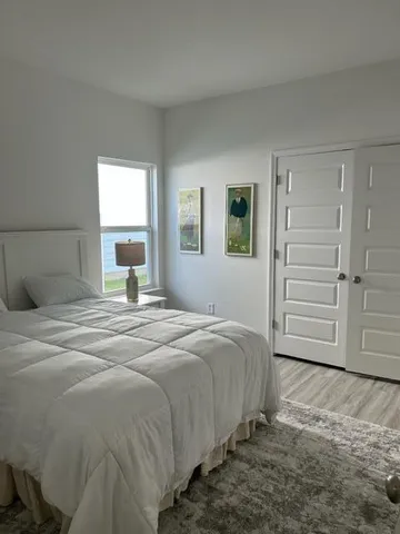 a bedroom with a bed a dresser and a window