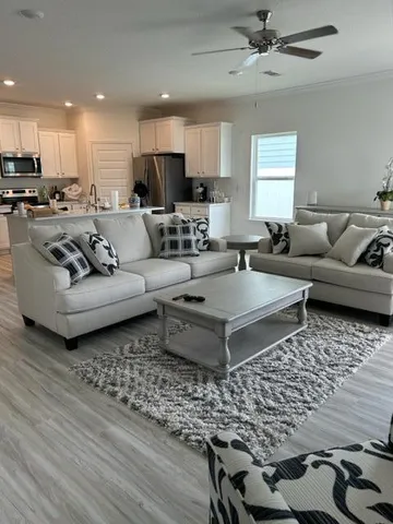 a living room with furniture wooden floor and a window