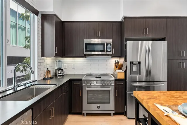 a kitchen with granite countertop a sink stove and refrigerator