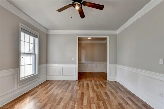 a view of an empty room with wooden floor and a fireplace