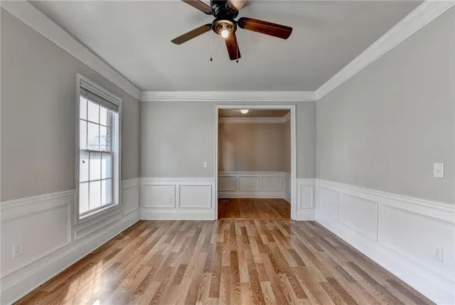 an empty room with wooden floor fireplace and windows