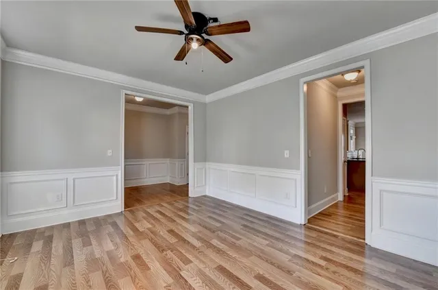 a view of an empty room with wooden floor fireplace and a window