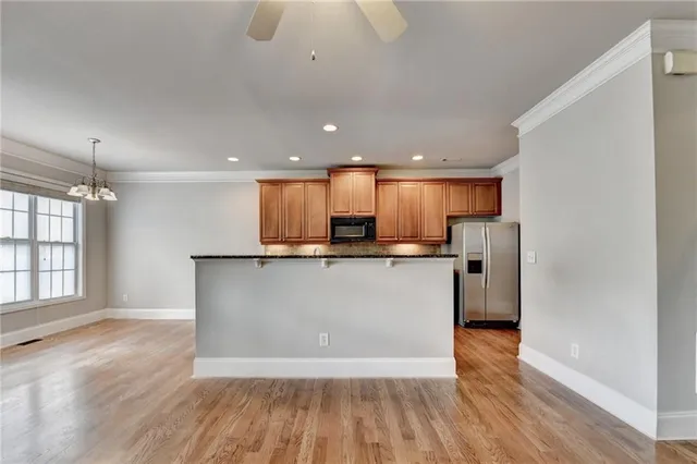 a kitchen with granite countertop kitchen island stainless steel appliances a sink stove top oven and cabinets