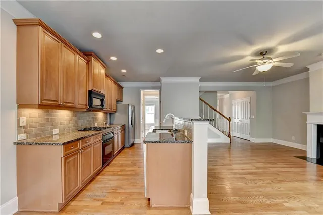a kitchen with granite countertop a stove top oven cabinets and a counter top space