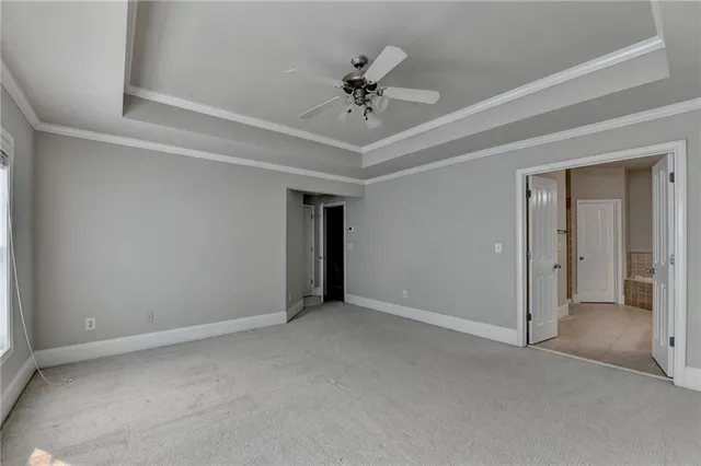 a view of an empty room and chandelier fan