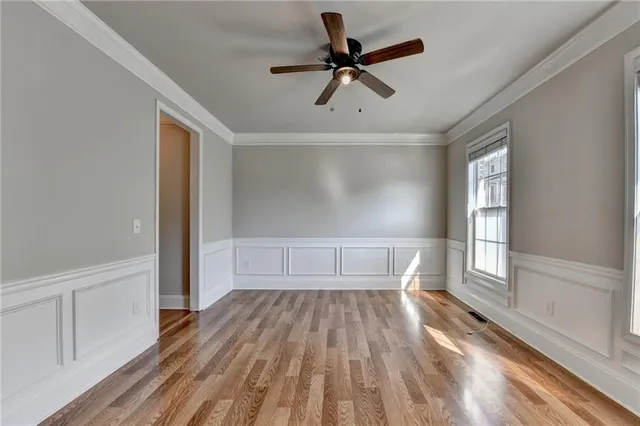 a view of empty room with wooden floor and window