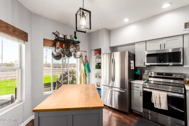 a kitchen with stainless steel appliances a refrigerator a stove a microwave and a view of living room