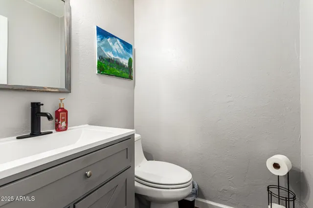 a bathroom with a toilet a sink and mirror
