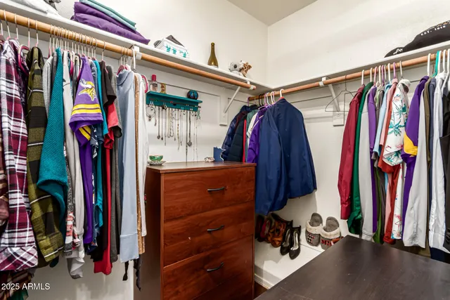 a view of walk in closet with clothes